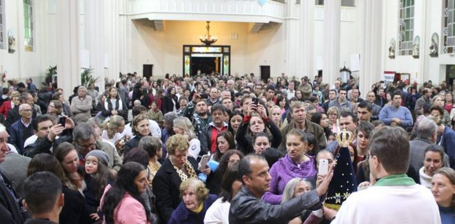 Fiéis ao final da missa, se aproximando da Imagem para fez sua devoção.